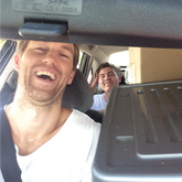 Image of 2 men in a car packed full of boxes