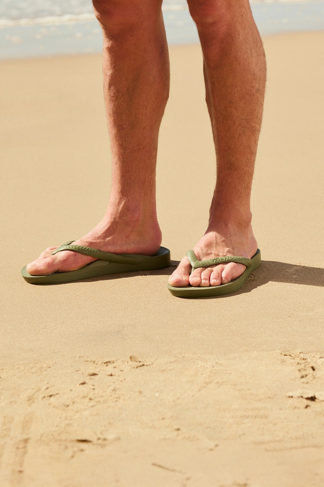 Close up of women's feet on steps wearing peach coloured flip flops